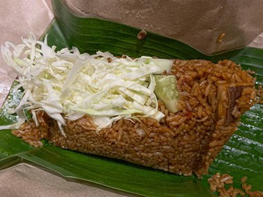 Geleneksel kahverengi kağıt ve muz yapraklarıyla Endonezya usulü kızarmış pirinç veya nasi goreng.