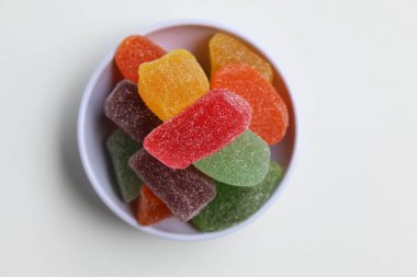 Renkli şekerleme ya da küçük beyaz tabakta meyveli jöle, beyaz arka planda izole, düz ya da üst görünümde