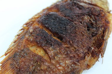 Fried gourami fish on a white plate, isolated on white background clipart