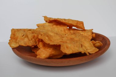 Kerupuk pangsit, ya da beyaz arka planda izole ahşap tabakta kızarmış, kalın derili hamur köftesi.