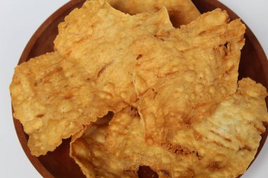 Kerupuk pangsit, ya da beyaz arka planda izole ahşap tabakta kızarmış, kalın derili hamur köftesi.