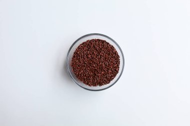 Chocolate sprinkles in transparent glass bowl, isolated on white background, flat lay or top view clipart