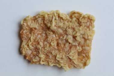 One piece of keripik tempe or tempeh crackers, square shape. Thin slices tempeh, fried with flour dough. Isolated in white background, flat lay or top view clipart