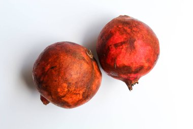 İki nar meyvesi, beyaz arka planda izole edilmiş.