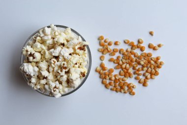 Kurutulmuş mısır çekirdekleri ve patlamış mısır, pişirmeden önce ve sonra, beyaz arka planda izole edilmiş.