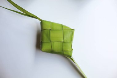 Ketupat ambalajı, pişmeden önce örülmüş taze hindistan cevizi yaprakları. Beyaz arkaplanda izole