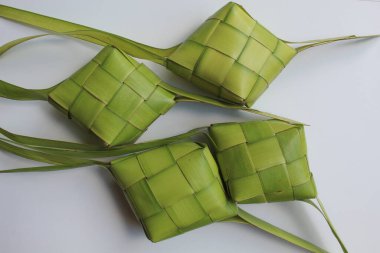 Ketupat ambalajı, pişmeden önce örülmüş taze hindistan cevizi yaprakları. Beyaz arkaplanda izole