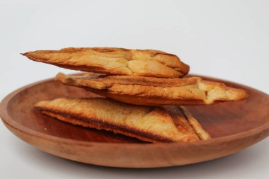 Kızarmış ekmek ya da kızarmış ekmek, ahşap tabakta, beyaz arka planda izole edilmiş.