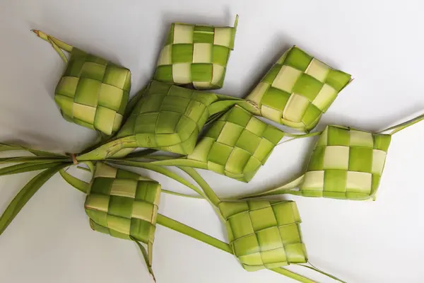 Ketupat ambalajı, pişmeden önce örülmüş taze hindistan cevizi yaprakları. Beyaz arkaplanda izole