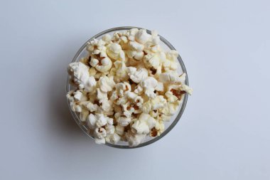 Şeffaf cam kasede patlamış mısır, beyaz arka planda izole, düz ya da üst görünüm