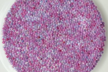 Mor silis jel boncuğun beyaz arka planda, daire şeklinde yakın deseni