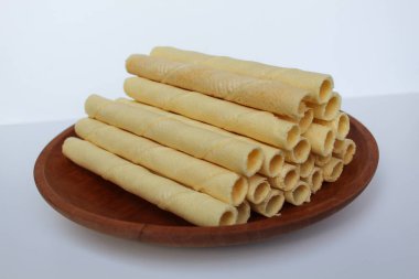 Egg rolls, original flavor. Rolled thin crepes. On wooden plate. Isolated on white background clipart