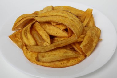 Kızarmış muz dilimleri ya da muz cipsi, beyaz tabakta, beyaz arka planda izole edilmiş.