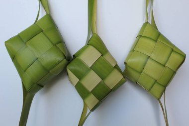 Ketupat ambalajı, pişmeden önce örülmüş taze hindistan cevizi yaprakları. Beyaz arkaplanda izole