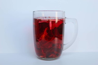 Wedang Uwuh, ya da geleneksel çay demlenmiş safir ağacı, zencefil, limon otu ve kakule. Şeffaf camda, beyaz arkaplanda izole edilmiş.