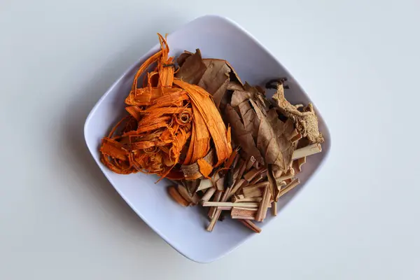 Wedang Uwuh, ya da beyaz arka planda izole edilmiş Java bitkisel içeceği. Hint sekodu, kurutulmuş zencefil, limon otu ve kakule karışımından önce. Düz ya da üst görünüm