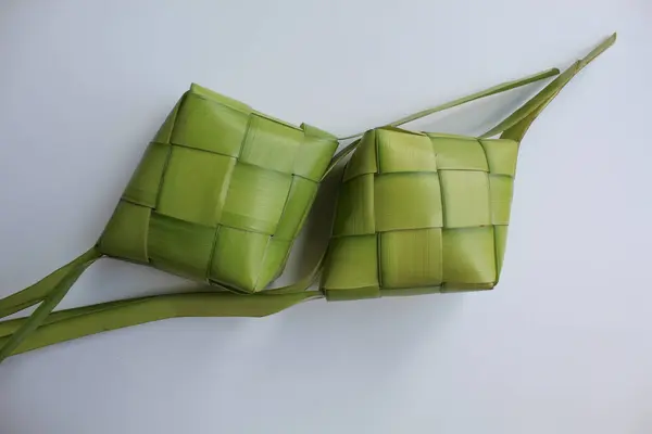 Ketupat ambalajı, pişmeden önce örülmüş taze hindistan cevizi yaprakları. Beyaz arkaplanda izole