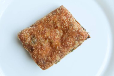 Martabak Telur 'dan bir parça. Yumurtalı gözleme, un ve pırasa dilimleri, Endonezya 'dan atıştırmalık. Beyaz arkaplanda izole