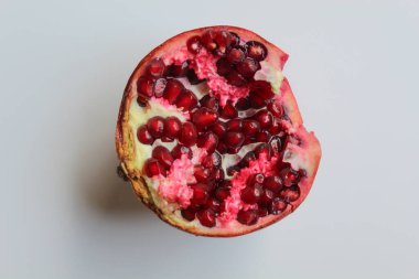 Nar meyvesinin içinde, beyaz arka planda izole edilmiş taze kırmızı tohumlar.