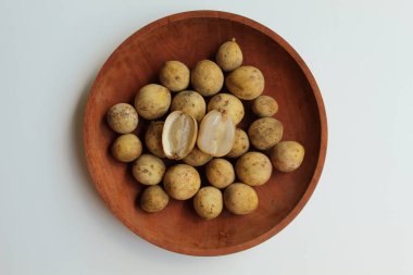 Duku olarak bilinen Lansium domesticum var duku meyvesi, ya da langsat, ya da lanzone, ahşap plaka üzerinde, beyaz arka planda izole edilmiş, düz ya da üst görünümde