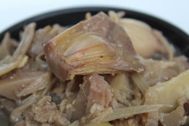 Hindistancevizi sütüyle pişirilmiş, siyah kâsede, beyaz arka planda izole edilmiş taze meyve eti.