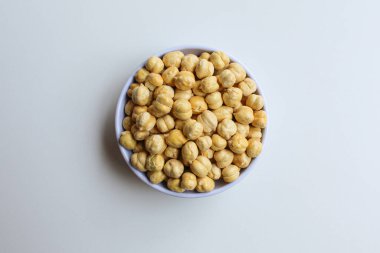 Küçük beyaz kasede nohut, beyaz zemin üzerinde izole, düz ya da üst görünüm