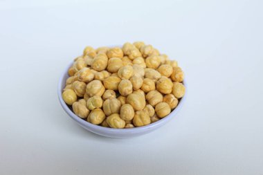 Beyaz arka planda izole edilmiş küçük beyaz kasede nohutlar.