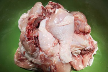 Raw chicken meat cuts inside green bowl, uncooked, selective focus clipart