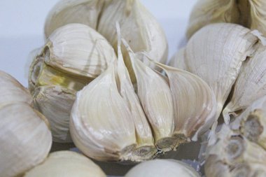 Tam sarımsaklı kafa ya da ampul, beyaz arka planda soyulmamış, pişirilmemiş.