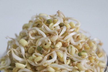 Mung bean sprouts, inside a transparent bowl, isolated on white background. Fresh and uncooked clipart