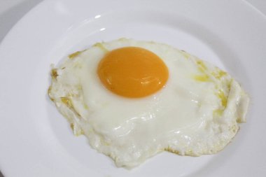 Kızarmış yumurta ya da beyaz bir tabakta güneşli tarafı. Ortadaki turuncu yumurta sarısı. Beyaz arkaplanda izole