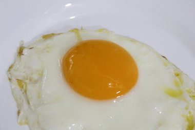 Kızarmış yumurta ya da beyaz bir tabakta güneşli tarafı. Ortadaki turuncu yumurta sarısı. Beyaz arkaplanda izole