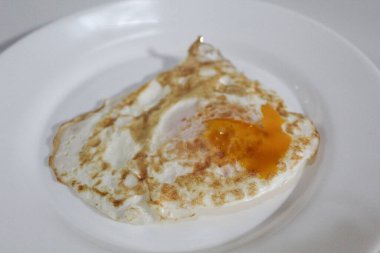 Beyaz tabakta sahanda yumurta. Ortadaki turuncu yumurta sarısı. Beyaz arkaplanda izole