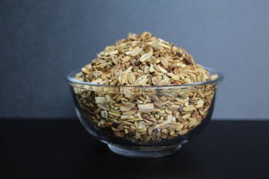 Aniseed 'in kurumuş granülleri, ya da Pimpinella Anisum tohumu, ya da Adas Manis, bir kasenin içinde. Siyah arkaplanda izole