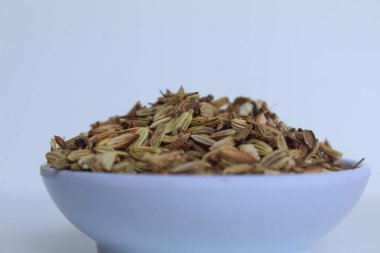 Aniseed 'in kurumuş granülleri, ya da Pimpinella Anisum tohumu, ya da Adas Manis, bir kasenin içinde. Beyaz arkaplanda izole