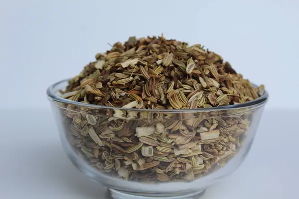 Aniseed 'in kurumuş granülleri, ya da Pimpinella Anisum tohumu, ya da Adas Manis, bir kasenin içinde. Beyaz arkaplanda izole