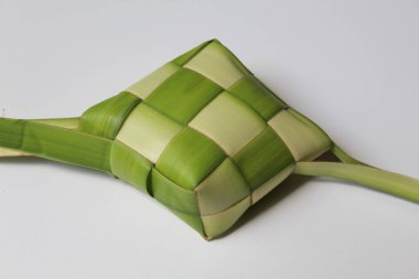 Bir ketupat dürüm, pişmeden önce örülmüş taze hindistan cevizi yaprakları. Beyaz arkaplanda izole