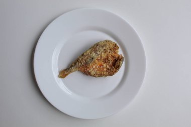 Kızarmış balık. Endonezya 'da Gereh ya da Ikan Asin olarak adlandırılan tuzlanmış, yarı kesilmiş, un kaplı balık, beyaz arka planda izole edilmiş.