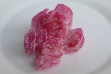 Manisan Pala, or candied nutmeg fruit, snack from Indonesia. In flower shaped, dried, covered by crystal sugar, isolated on white background clipart