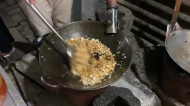 Sokak satıcılarından geleneksel kızarmış pirinç pişirme işlemi. Soya soslu pilav ve küçük metal tavada ya da tavada baharat. Endonezya usulü kızarmış pirinç veya nasi goreng.