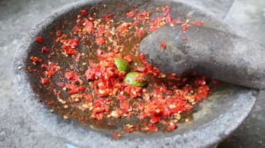 Ezilmiş kırmızı biber ve taştan harç ve kireç üzerine yakınlaştırın, adı Sambal, Endonezya 'nın yemek çeşidi.