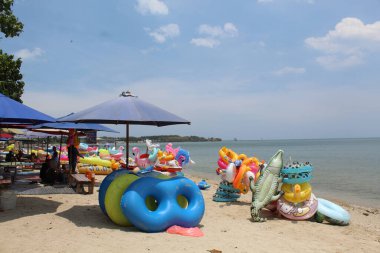 Yüzme ringi, çeşitli renkler ve şekillerle sahilde kiralık. 24 Eylül 2022 'de Jepara, Endonezya