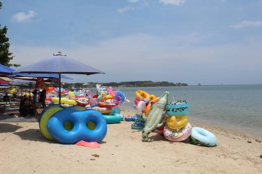 Yüzme ringi, çeşitli renkler ve şekillerle sahilde kiralık. 24 Eylül 2022 'de Jepara, Endonezya