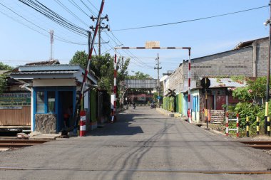 Demiryolu kapısı, sürücülerin rayları geçmesini engellemek için bir bariyer ya da kapı olarak kullanılıyor. 25 Eylül 2022 'de Semarang, Endonezya