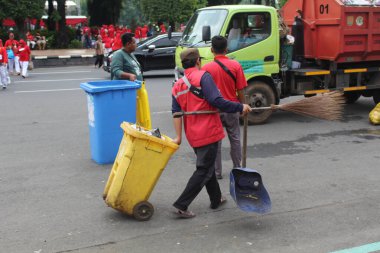 Waste collector from Environmental Ministry are working to collect garbage and the waste bin. In April 12th 2022 on Semarang, Indonesia clipart