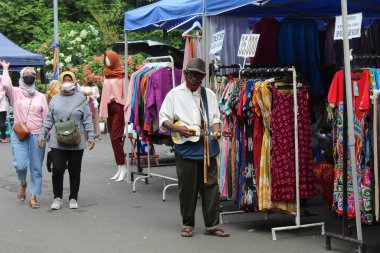 Geleneksel pazarda sokak çalgıcısı olarak çalışan yaşlı bir Asyalı. 12 Nisan 2022 'de Semarang, Endonezya