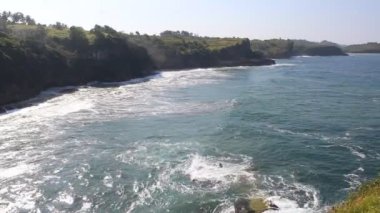 Deniz dalgaları deniz yığınına çarpar ve deniz köpüğü oluşturur. Pacitan, Endonezya 'daki Klayar Sahili manzarası
