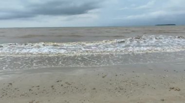 Çamurlu deniz suyu olan boş bir sahil.