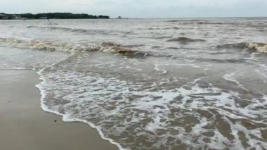 Çamurlu deniz suyu olan boş bir sahil.