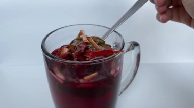 Wedang Uwuh, ya da geleneksel çay demlenmiş safir ağacı, zencefil, limon otu ve kakule. Şeffaf camda, beyaz arkaplanda izole edilmiş.